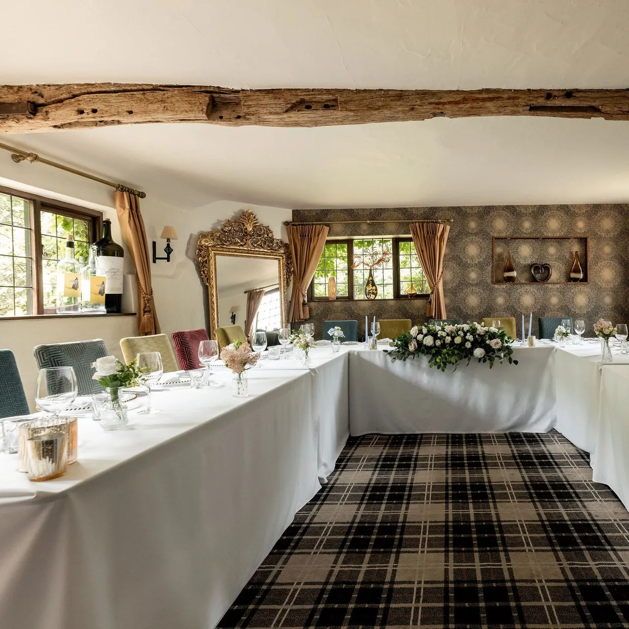 Elegant dining room with U-shaped table setting, floral centerpiece, and rustic decor