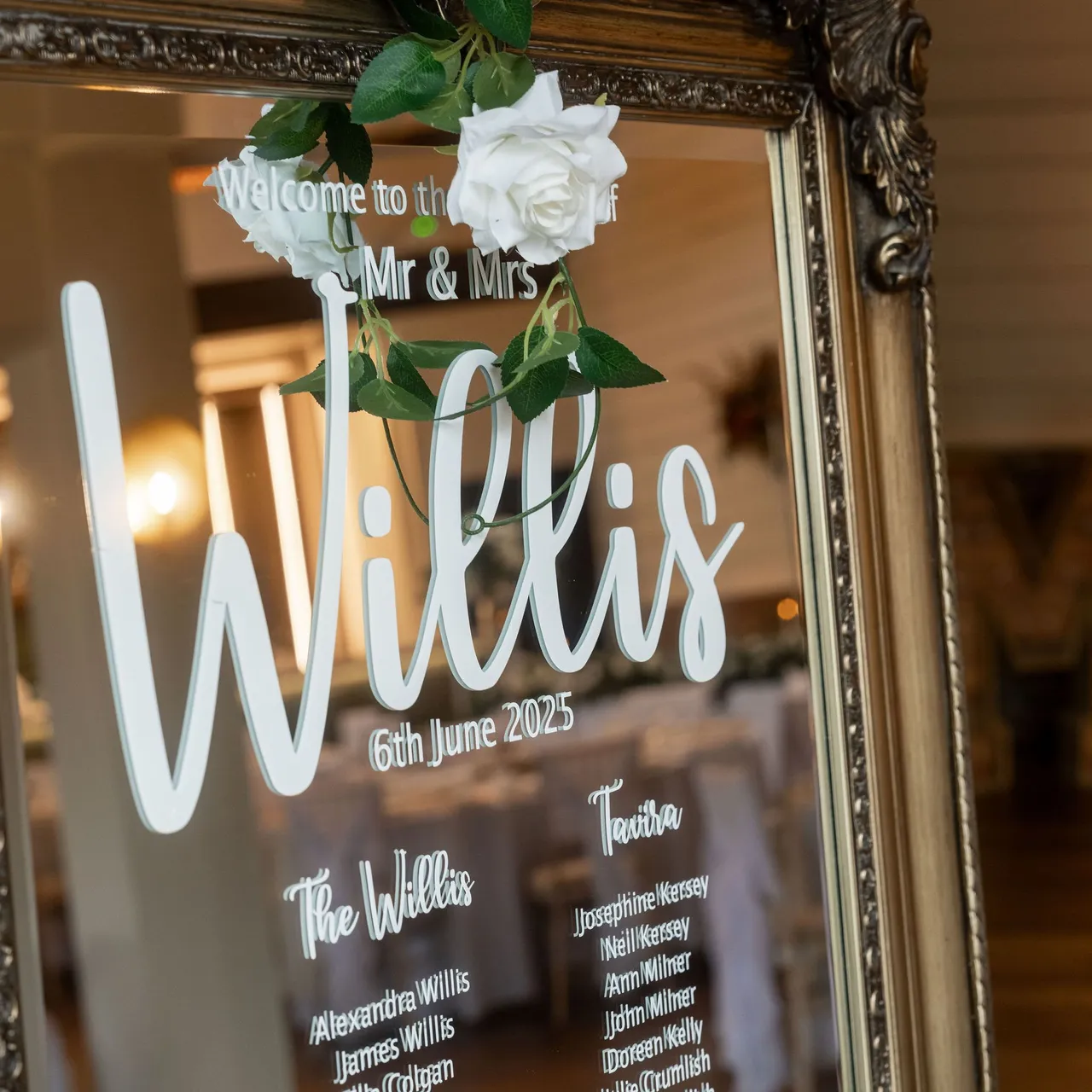 Framed wedding seating chart with white roses and guest names for the Willis wedding.